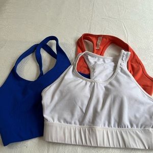 Three sports bras size M. Blue & white are Fabletics, orange is Lucy.